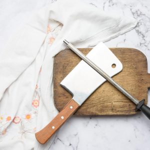 knife and old iron sharpener with handle for kitchen knives on a white background, top view